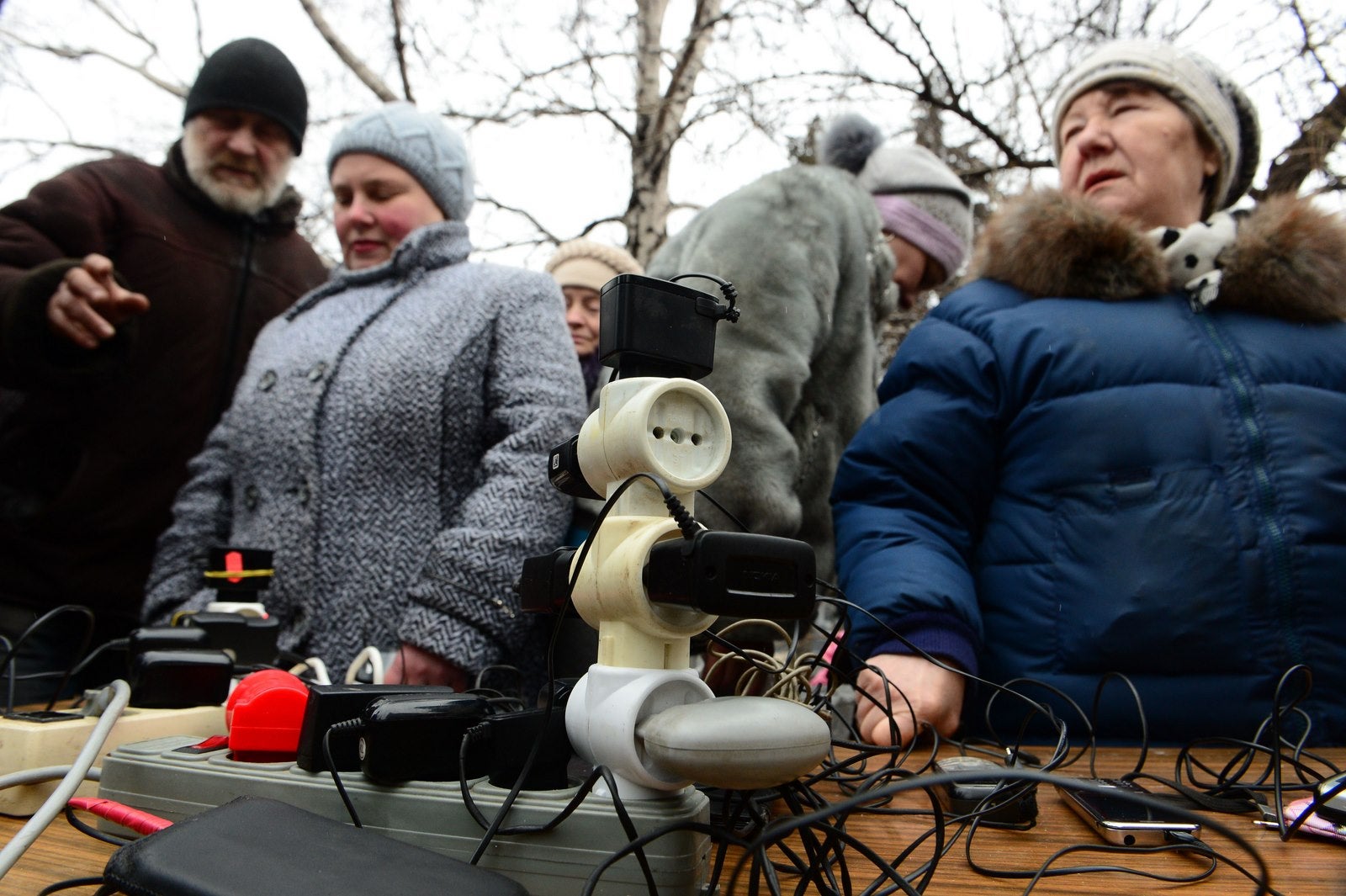 Residentes cargan sus dispositivos móviles en un generador móvil cerca de un comedor improvisado en la plaza de Lenin en Debáltsevo.