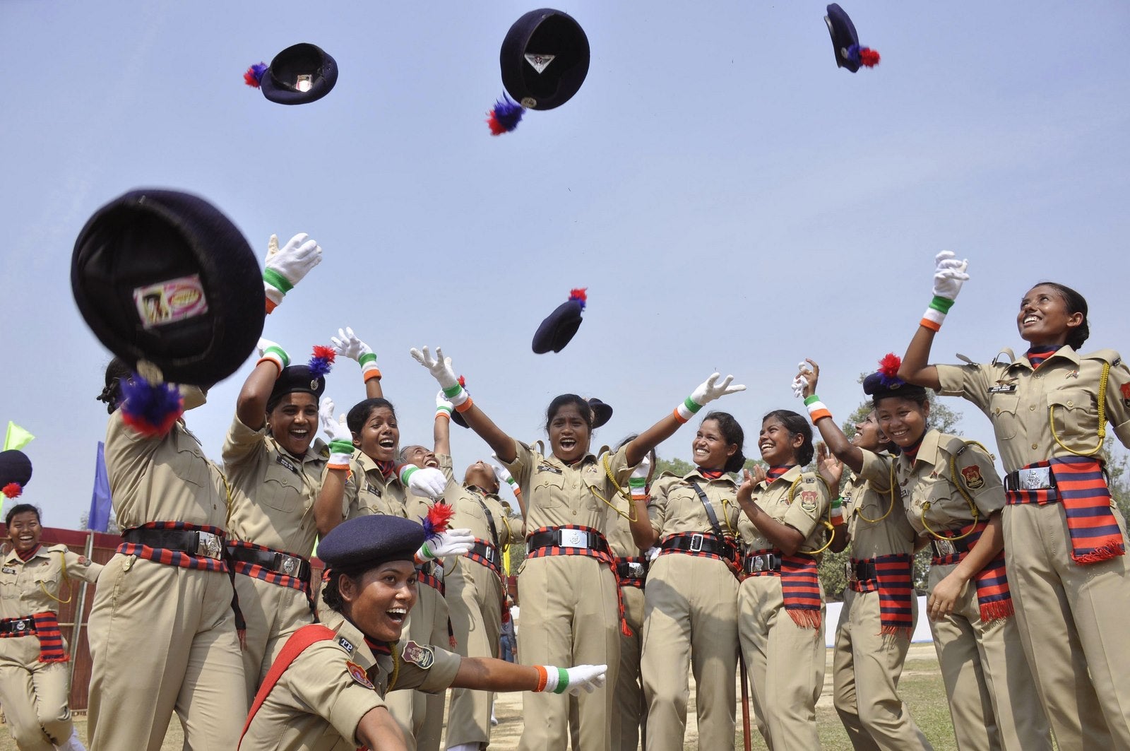 Policías indios lanzan sus boinas en el aire después de un desfile de guardias femeninos en un campo de entrenamiento de la policía en las afueras de Agartala.