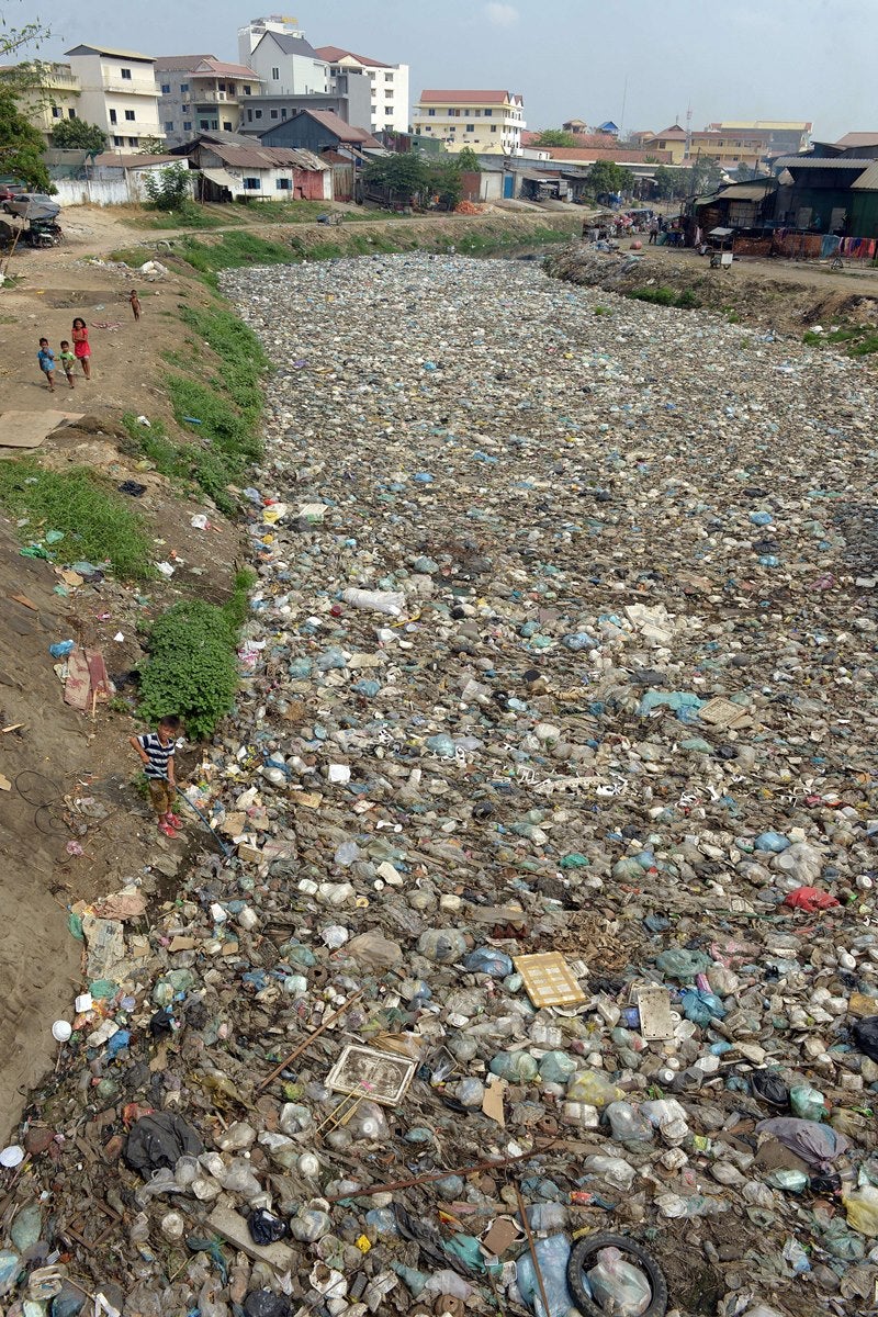 Niños camboyanos juegan junto en un canal lleno de residuos en Phnom Penh.