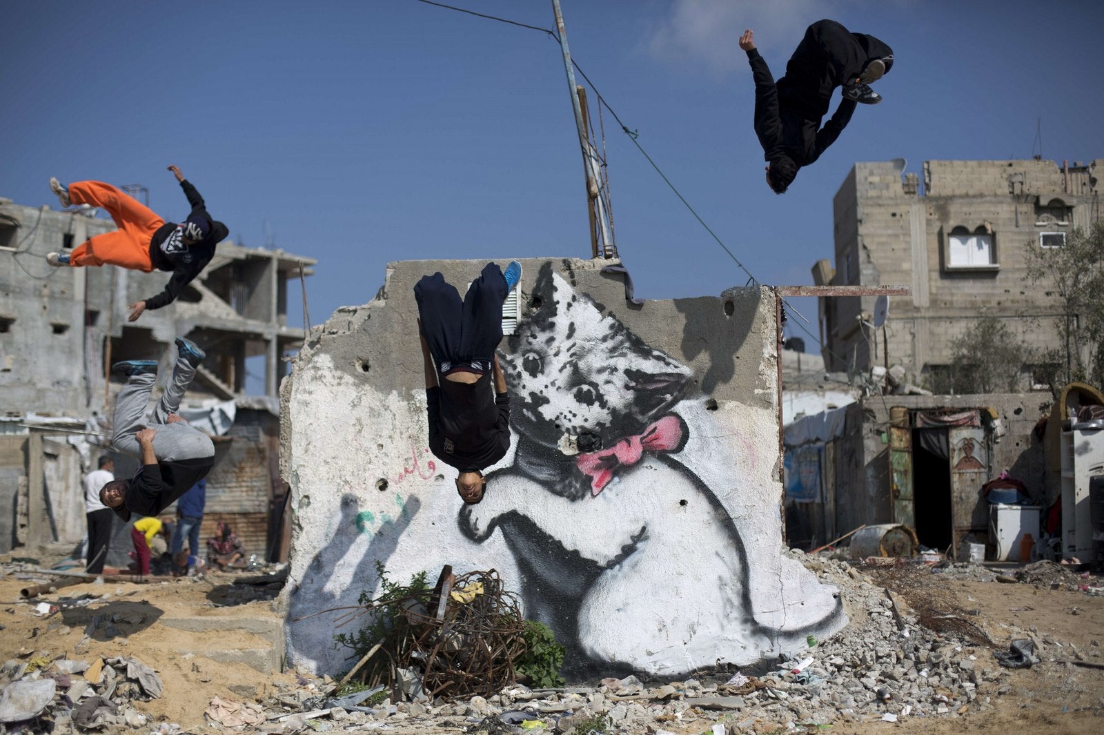 Jóvenes palestinos practican sus habilidades de Parkour en un mural pintado por el artista callejero británico Banksy.