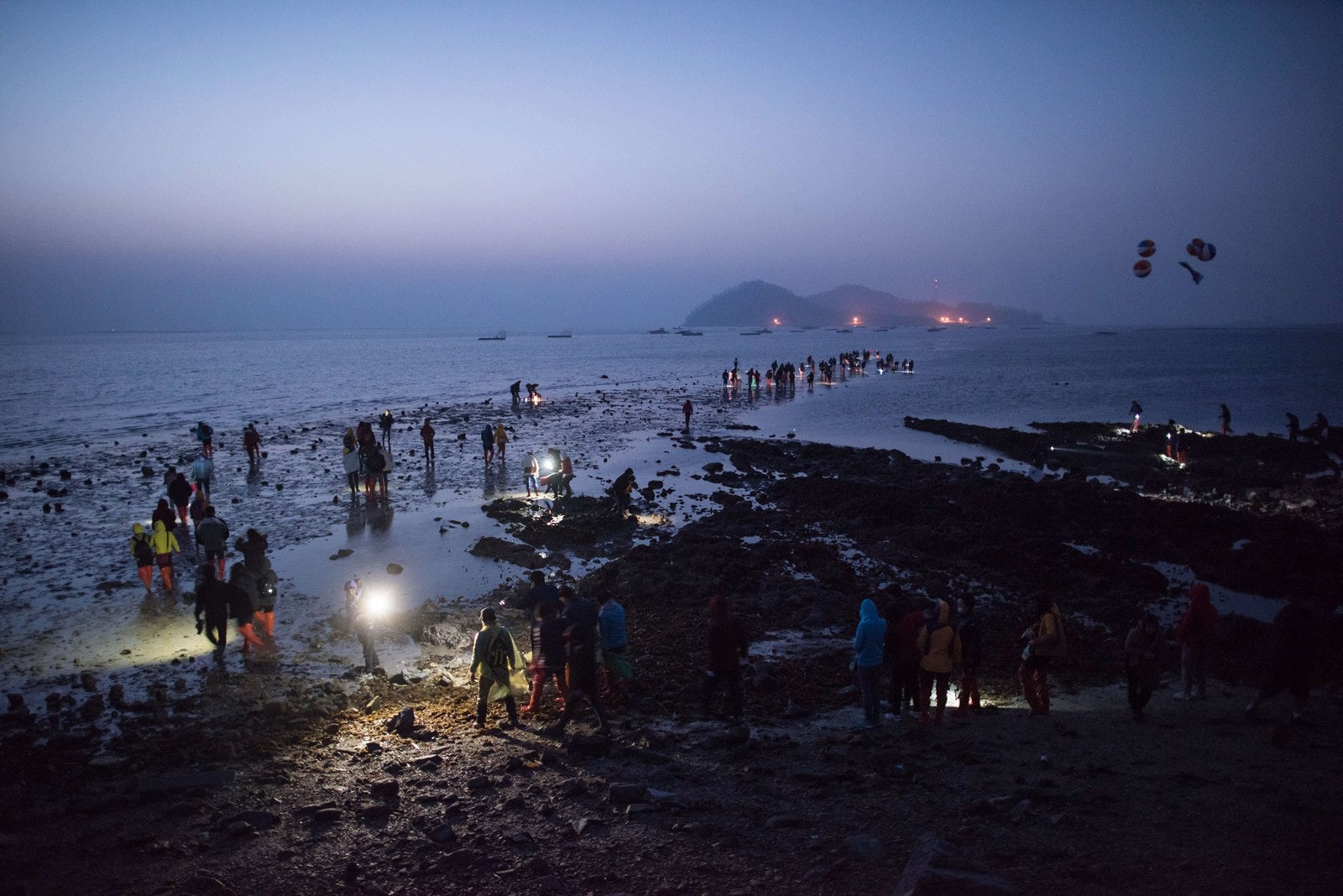 La gente sale a la mar aprovechando la marea baja de la mañana, entre las islas de Corea del Sur de Jindo y Modo durante el 'Jindo Mar del festival de despedida'.
