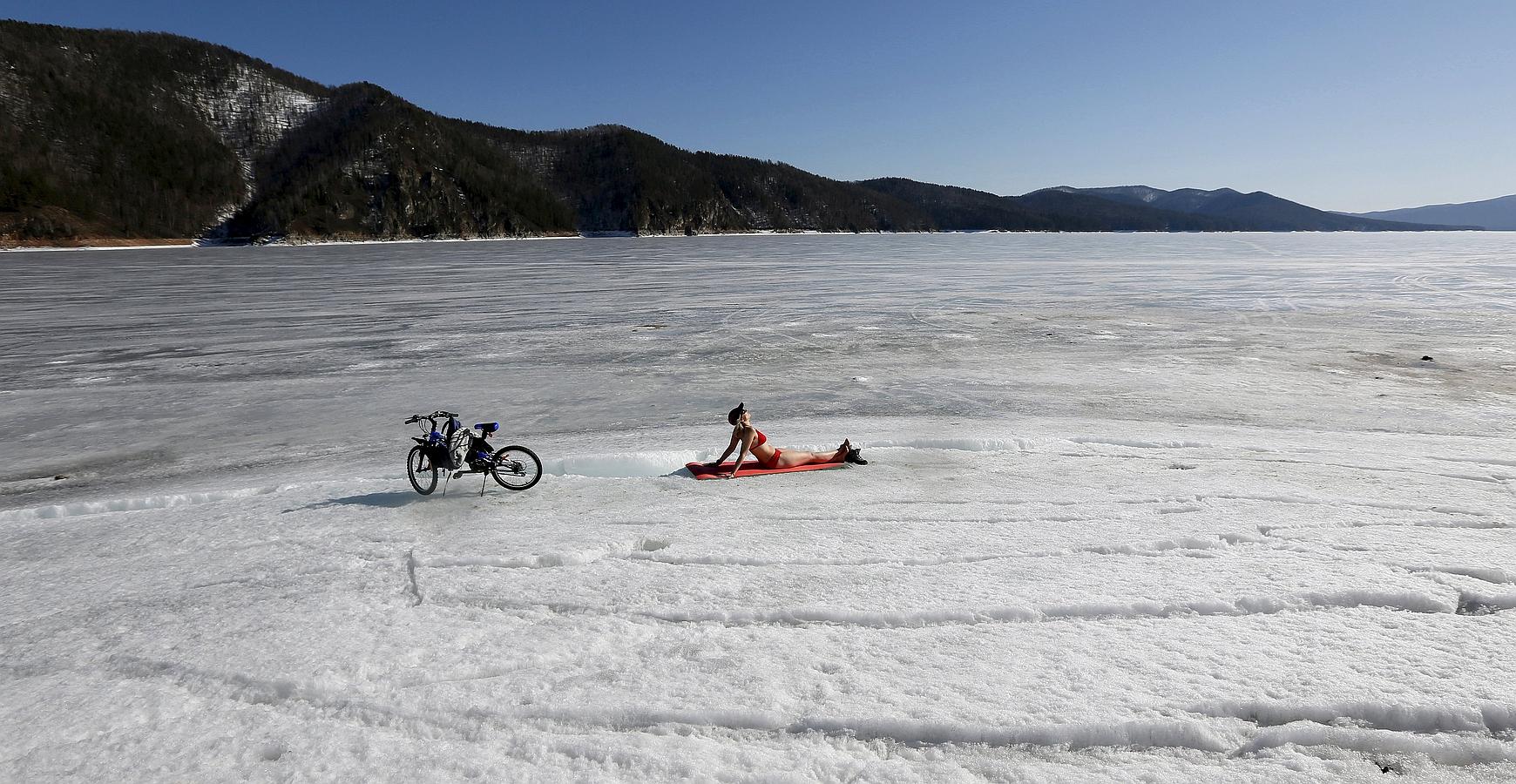 Una mujer disfruta del sol en la orilla del río Yenisei.