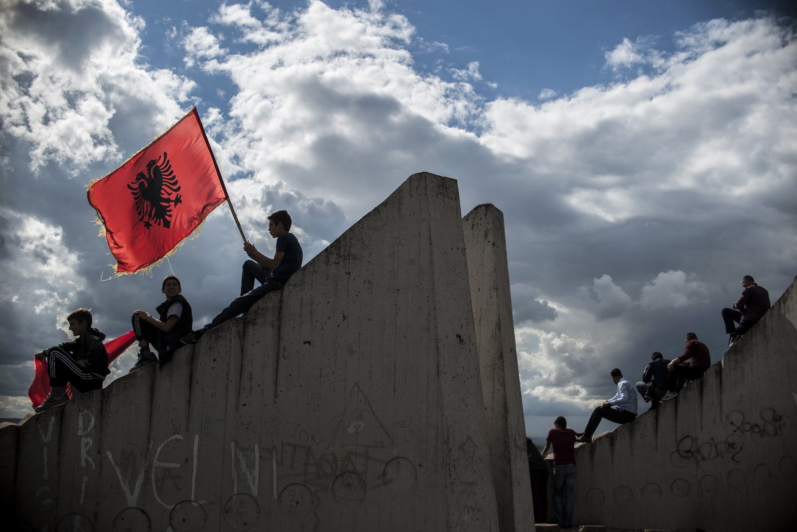 Un Kosovo albanes ondea la bandera albanesa durante una ceremonia fúnebre por ocho albaneses que murieron durante los enfrentamientos con la policía macedonia en Kumanovo.