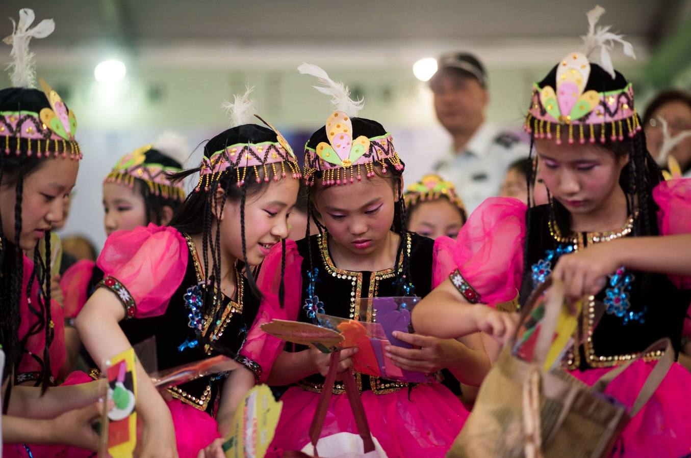 Las jóvenes vestidos con trajes de Mongolia Interior se preparan para un espectáculo durante un festival de promoción de té en un parque en Shanghai el 1 de junio de 2015, durante el Día Internacional del Niño.