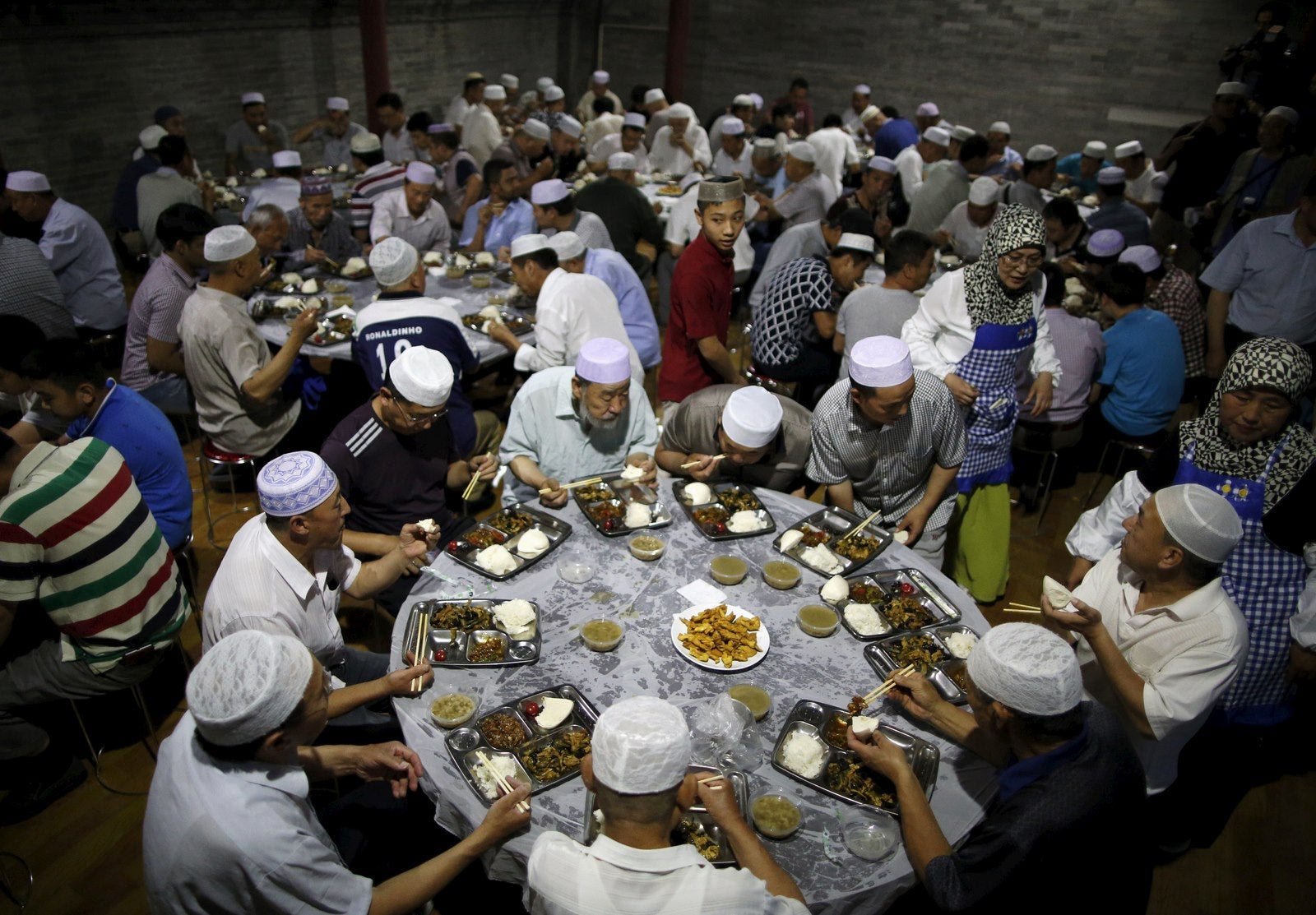 Musulmanes comen, ya que rompen rápido en el primer día del mes de ayuno del Ramadán en la Mezquita Niujie en Beijing, China.