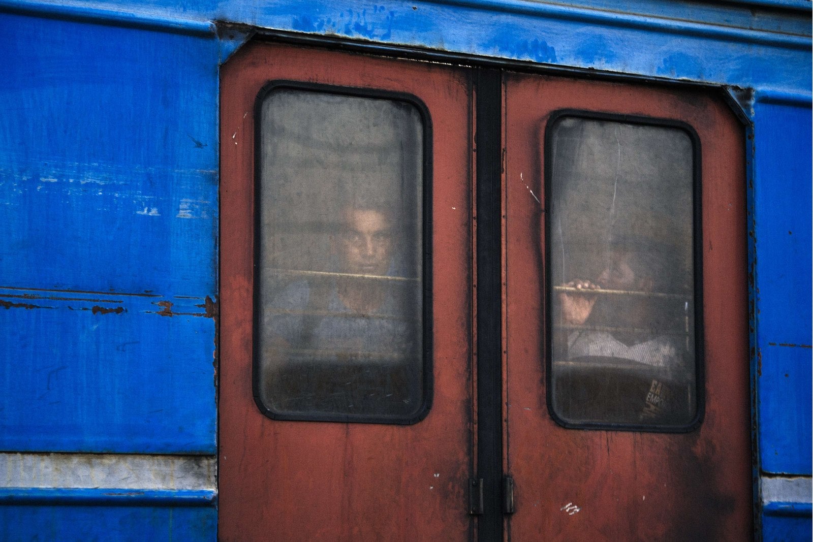 [Titulo]. Inmigrantes miran desde un tren que se prepara para salir hacia Serbia.