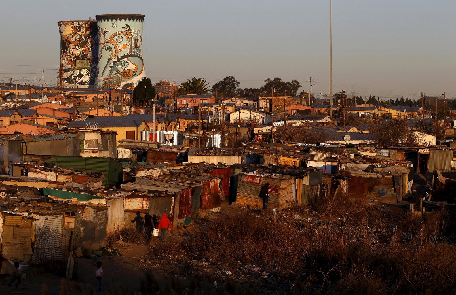 Torres de refrigeración no utilizadas vistas desde un asentamiento  en Soweto, Sudáfrica.