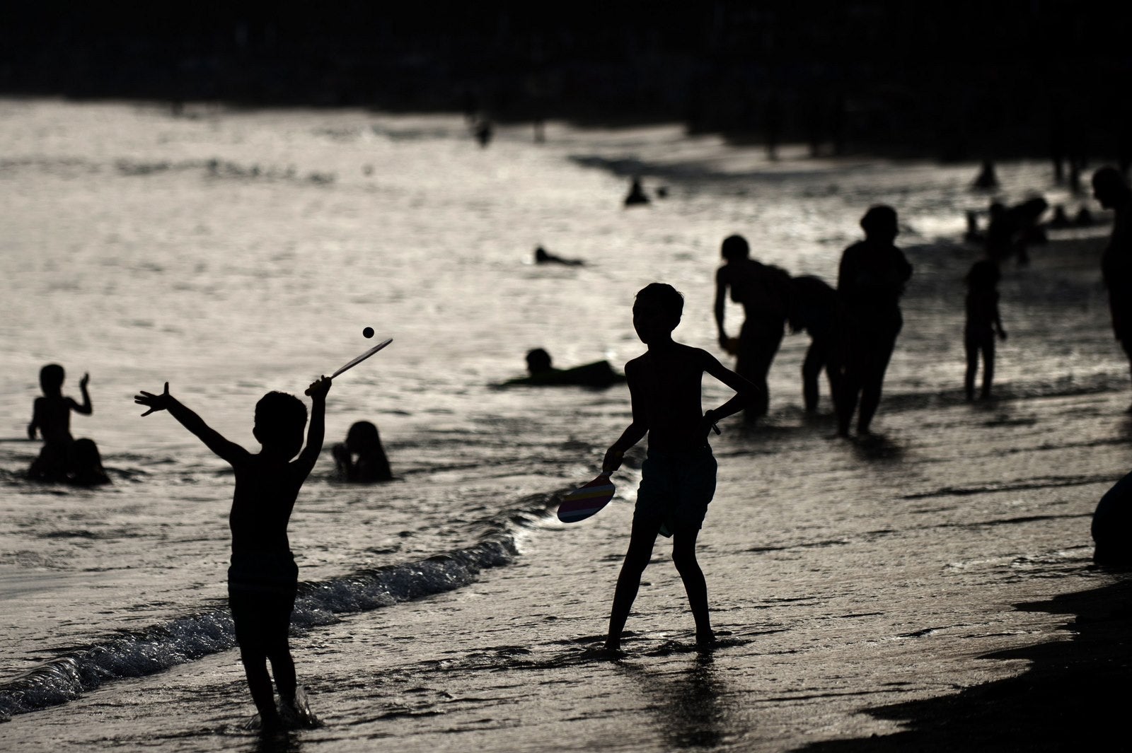 Niños juegan a las palas en la orilla de la playa de Marbella.