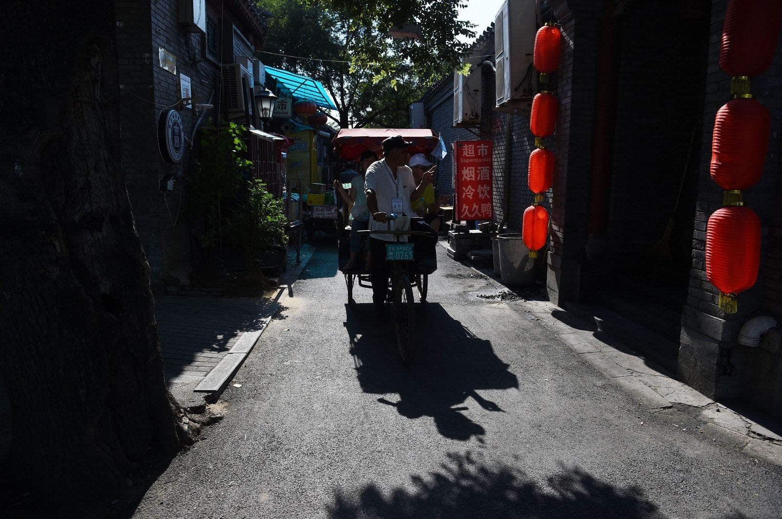 Un triciclo lleva a los turistas en una visita guiada a través de "hutongs" tradicionales, redes de callejones que unen casas con patio, en una zona restaurada en Beijing.