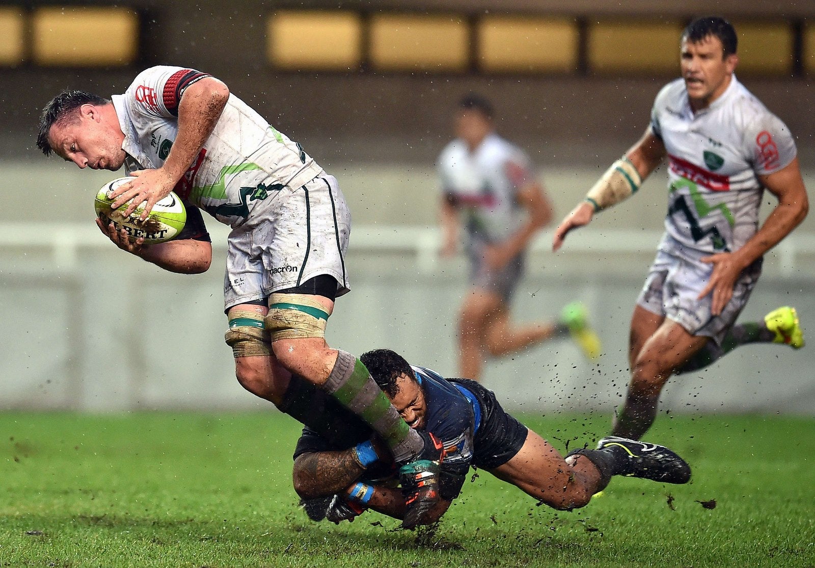 El jugador irlandes Paul James Coughlan (L) es placado por el centro neozelandés de Montpellier Anthony Tuitavake (C) durante el partido de rugby entre Montpellier y Pau.