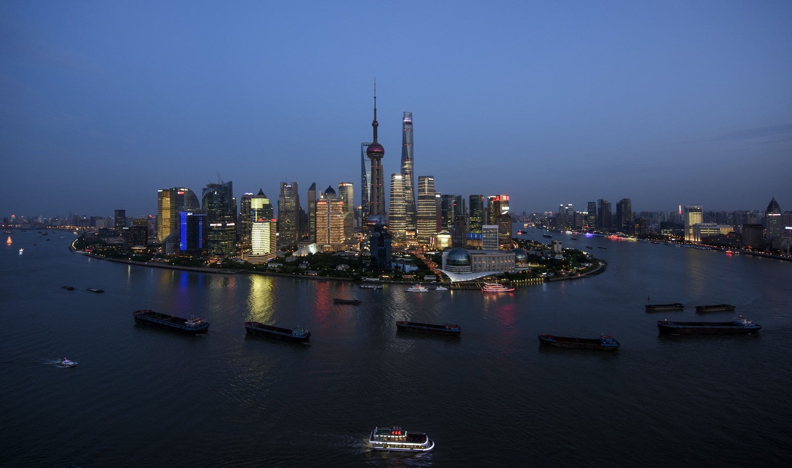 Barcos pasan por el horizonte del distrito financiero de Lujiazui en Pudong en Shanghai.