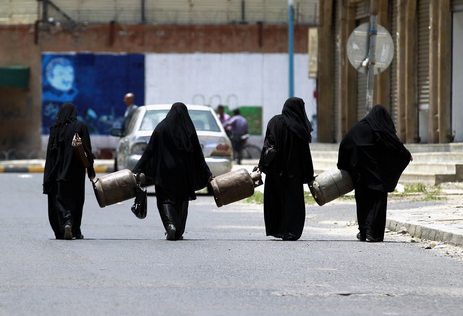 Mujeres yemeníes llevan bombonas de gas vacías, para tratar de rellenarlas en una gasolinera cercana, en medio de una creciente escasez de combustible en la capital Saná.