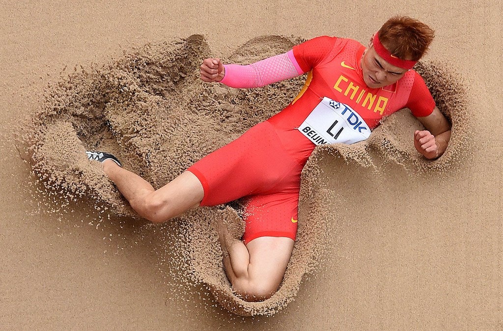 Li Jinzhe compite en la ronda de clasificación  de atletismo de salto masculino en el Campeonato Mundial de la IAAF 2015 en el Estadio Nacional de Beijing.