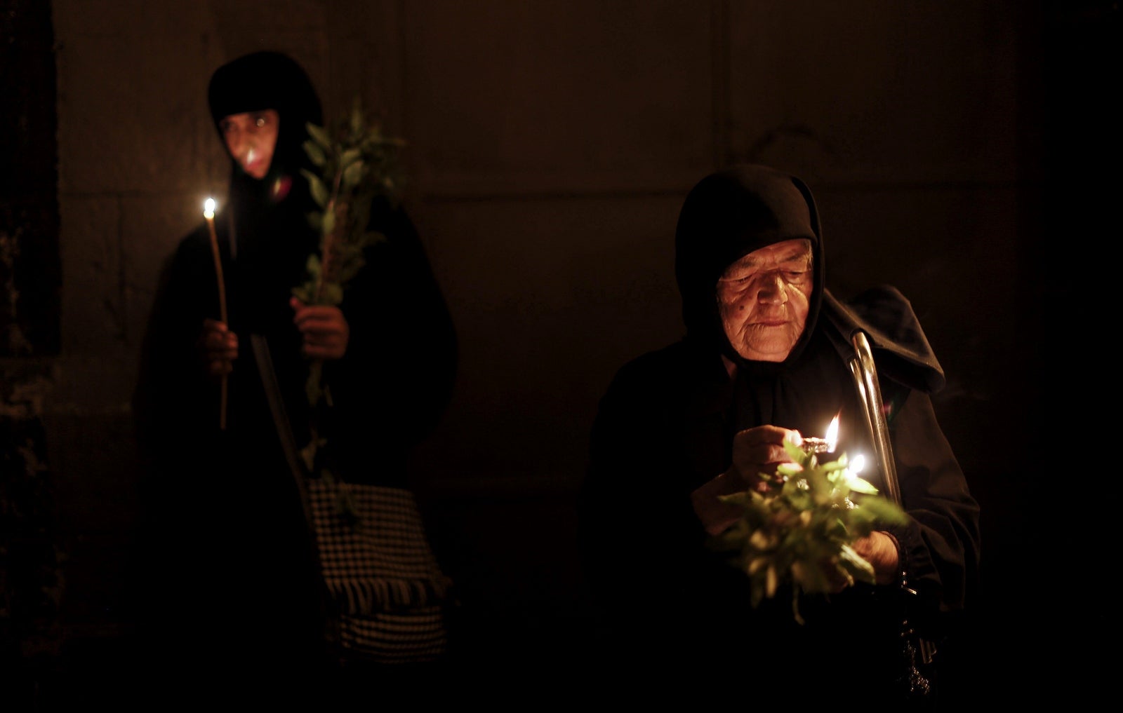 Varias religiosas llevan velas mientras participan en una procesión por la festividad de la Asunción de la Virgen María en Jerusalén, la procesión comienza en la Iglesia del Santo Sepulcro y recorre la Vía Dolorosa.