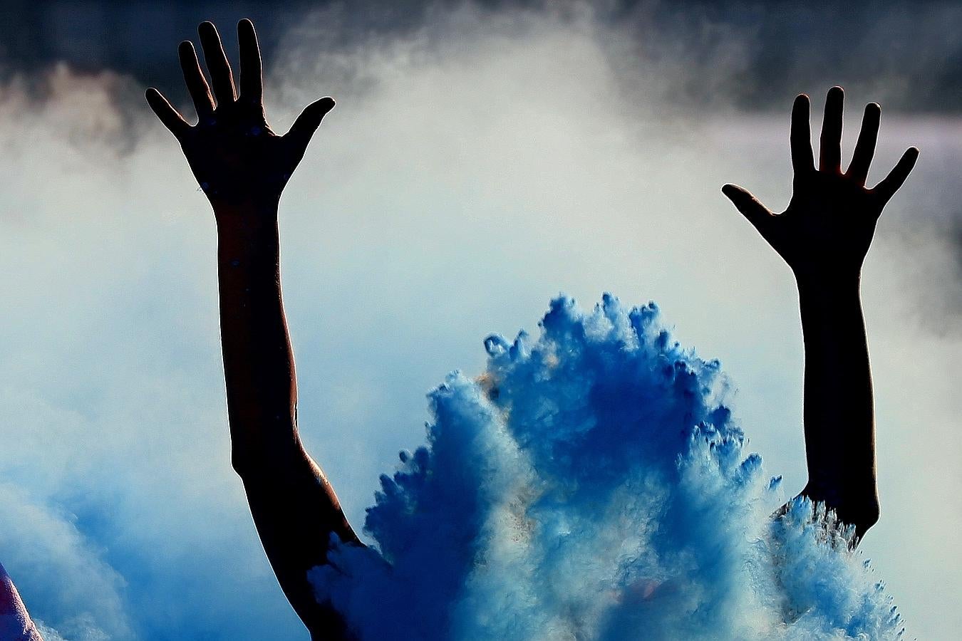 Una persona participa en una carrera de arco iris en Brno, República Checa. Las personas que participan en los 5km se tiran polvos de colores durante la carrera.