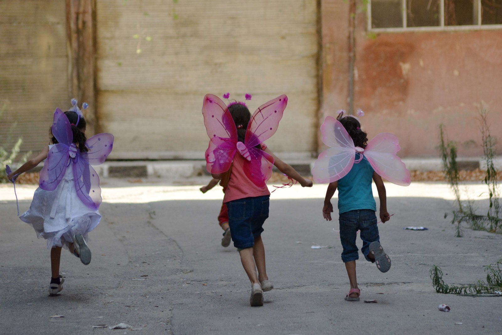 Niñas palestinas vistiendo trajes juegan en el campo de refugiados de Yarmuk sitiada en la capital siria, Damasco.