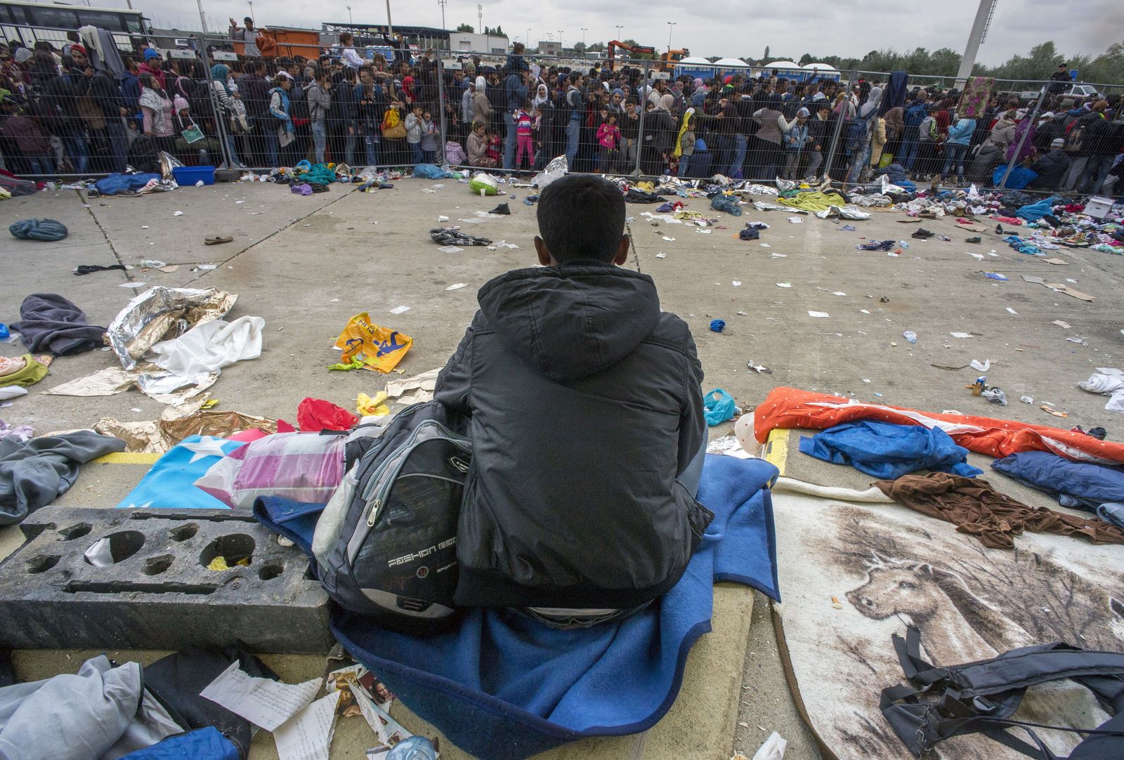 Un inmigrante se sienta como cientos están a la espera de los autobuses en la antigua estación de camiones de encargo cerca Nickelsdorf, Austria en la frontera entre Hungría y Austria.