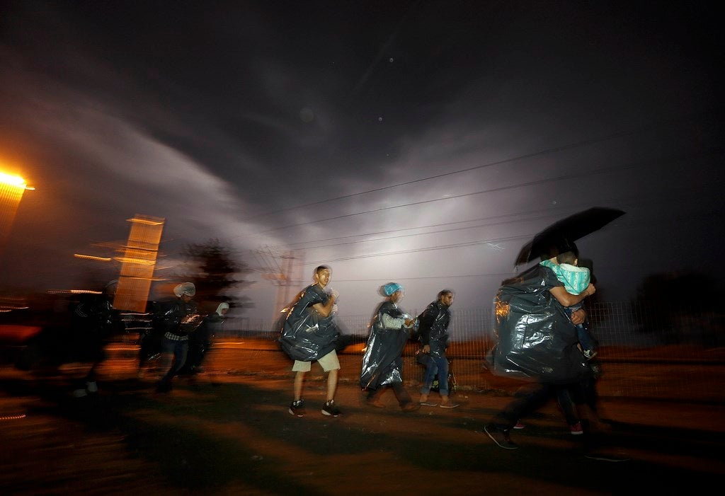 Refugiados sirios se apresuran hacia la frontera de Grecia con Macedonia cuando una tormenta se acerca a la aldea griega de Idomeni. REUTERS / Yannis Behrakis