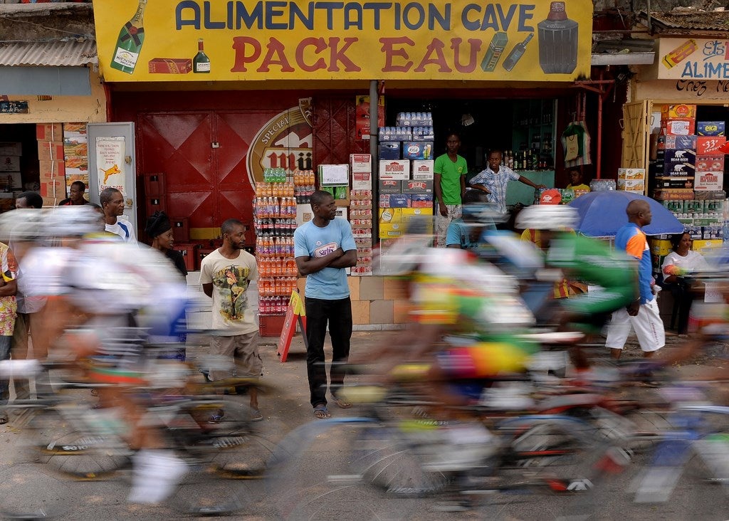 Personas miran como el peloton de ciclistas que compiten en 150 kilometros en bicicleta de la final en los Juegos de África del , en Brazzaville, Congo.