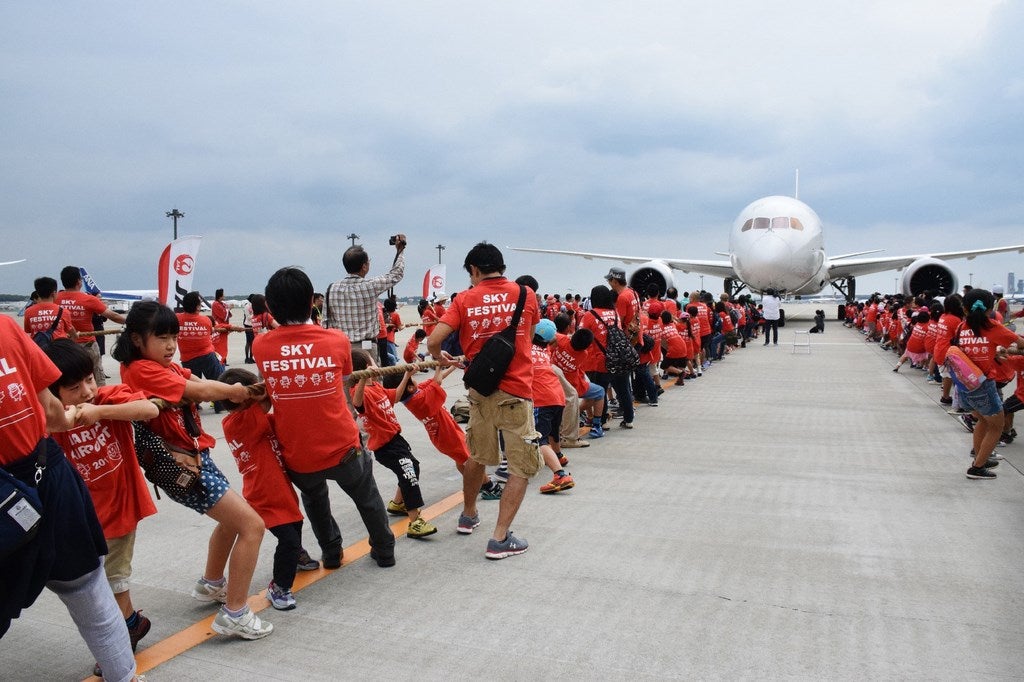 166 niños de la escuela primaria y sus 112 padres tirar de un avión de pasajeros Boeing 787 en el aeropuerto internacional de Narita en Narita, suburbio de Tokio.