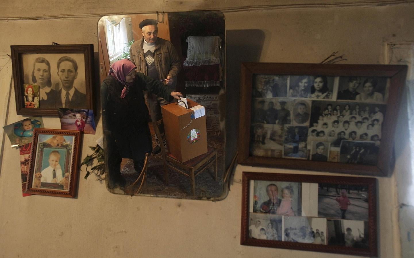 Una mujer se refleja en un espejo mientras ingtroduce una papeleta en una caja de votación portátil durante una elección presidencial en el pueblo de Danilovichi, al suroeste de Minsk, Bielorrusia.