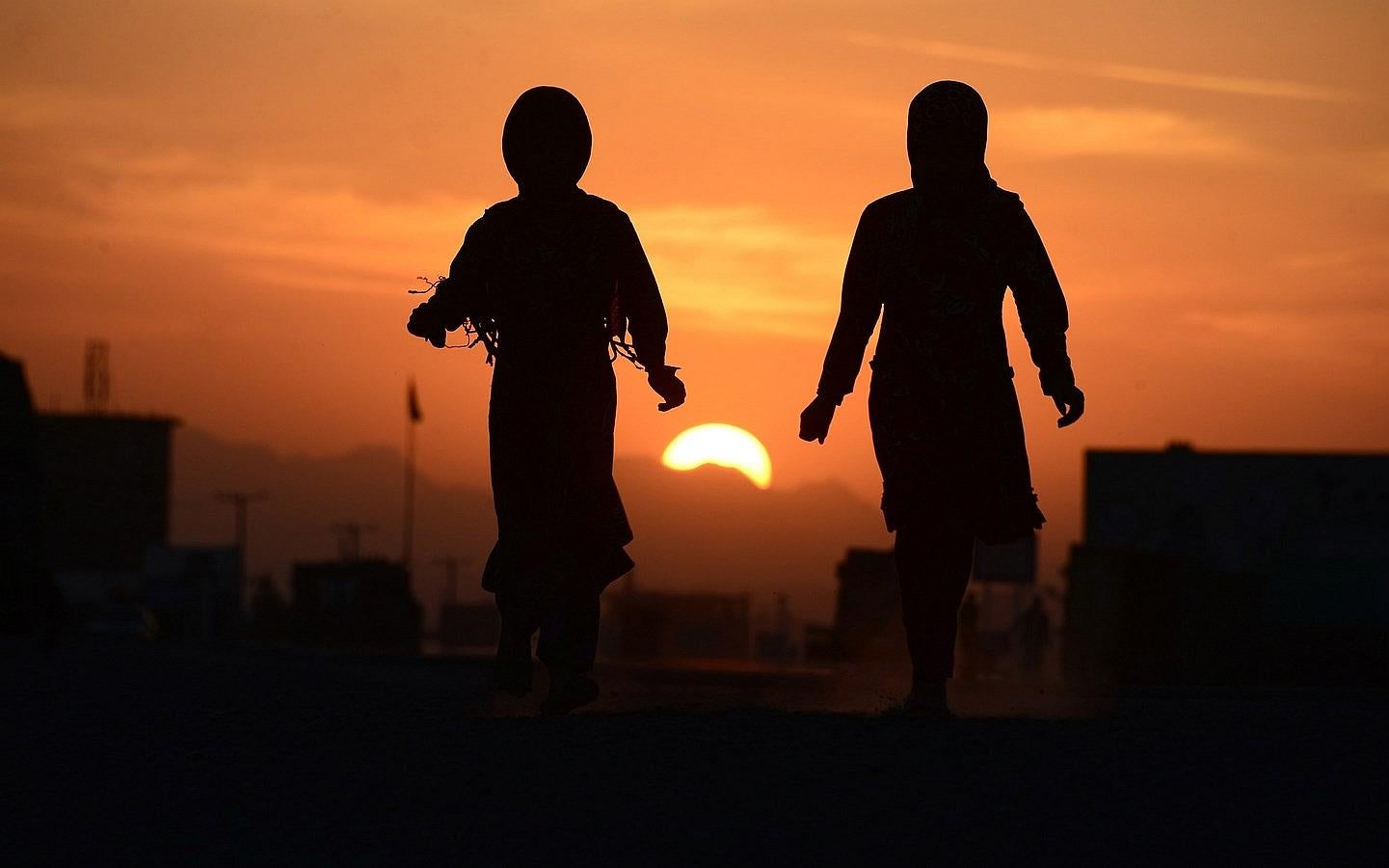 Niñas refugiadas afganas caminando entre las carpas en las afueras de Herat.