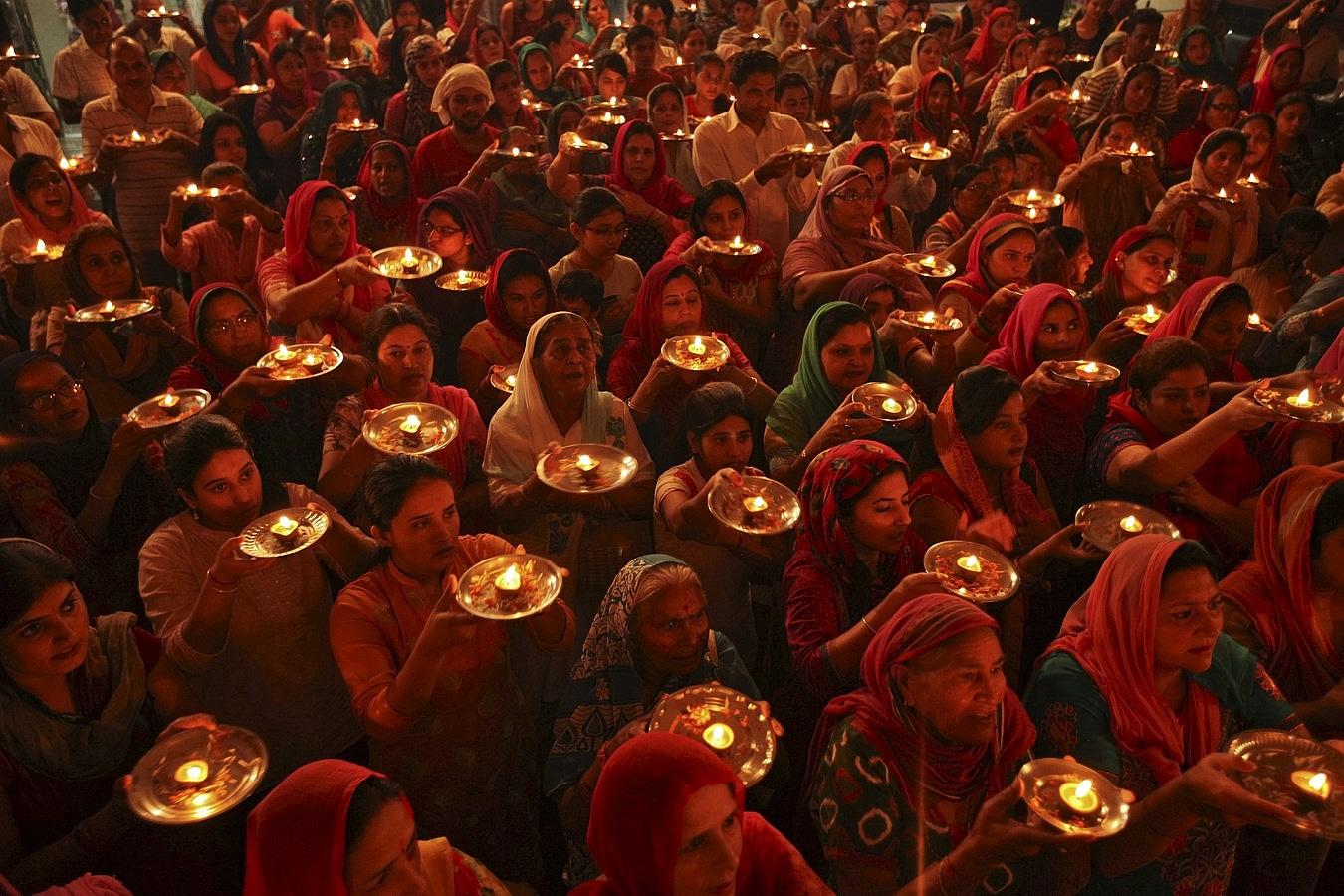 Devotos hindúes con lámparas de aceite de barro rezan dentro de un templo durante el festival de Navratri en Chandigarh, India. El festival, que se celebra en honor de la diosa hindú Durga, que simboliza el poder y el triunfo del bien sobre el mal.