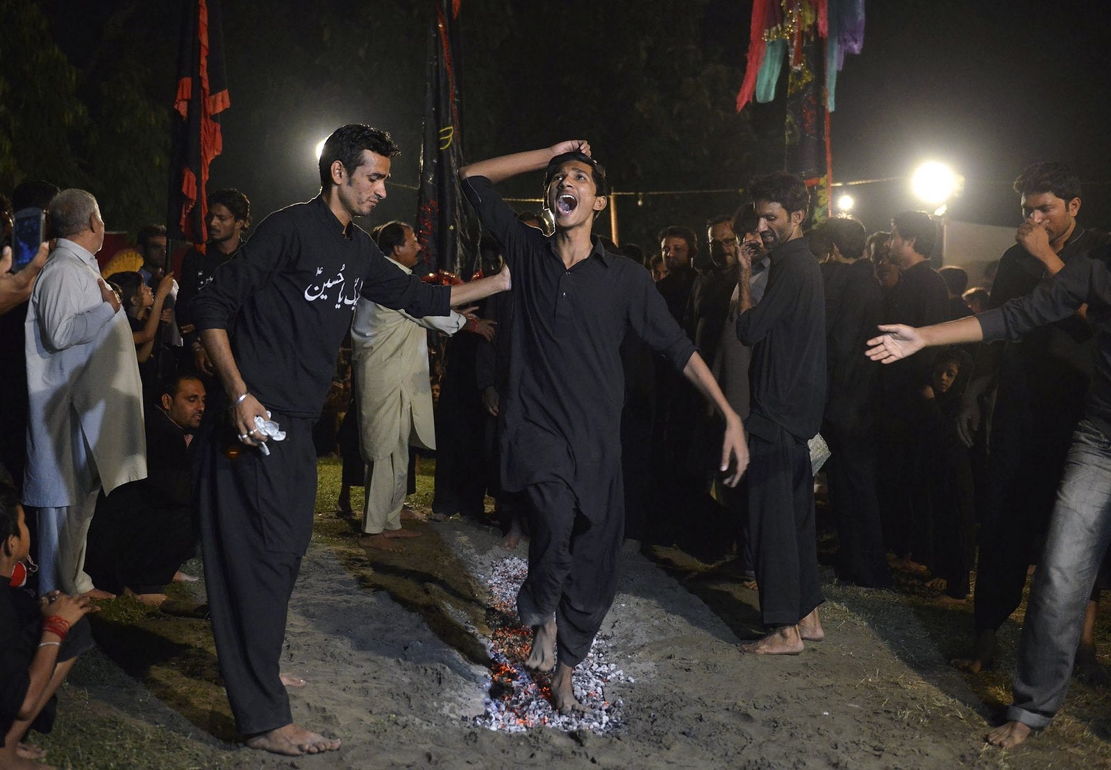 Un paquistaní chiíta musulmán camina sobre brasas de carbón durante una conmemoración del martirio del imán Husein, nieto del profeta Mahoma, en Lahore.