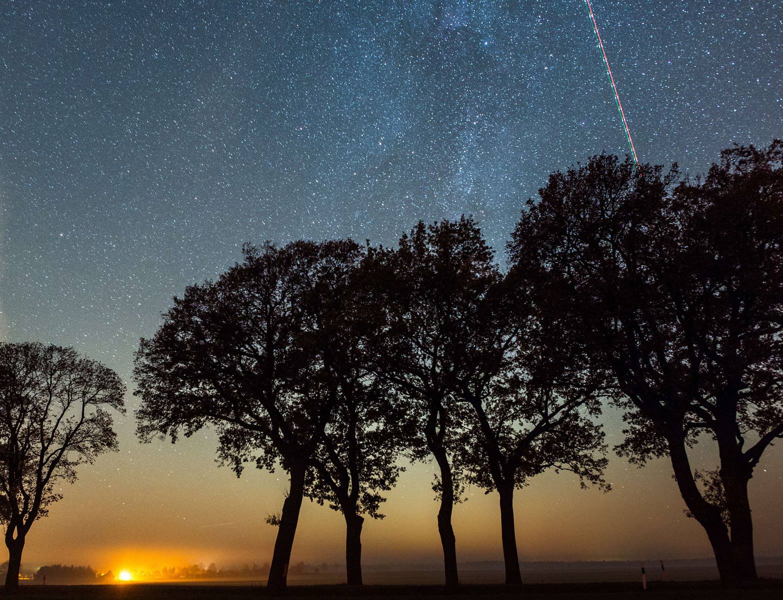 Un avión cruzan el cielo que está salpicado de estrellas de la Vía Láctea cerca de Petersdorf, al noreste de Alemania.