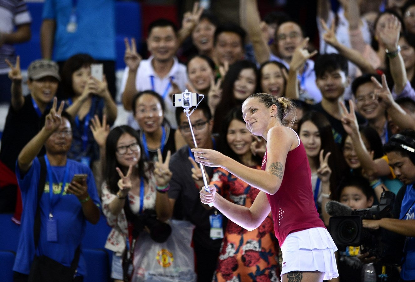 Karolina Pliskova de la República Checa utiliza un palo selfie para hacer unas fotos con los fans después de ganar el individual femenino de semifinal contra Elina Svitolina de Ucrania en el Trofeo Elite WTA en Zhuhai, provincia meridional china de Guangdong. CHINA OUT AFP PHOTO / STR