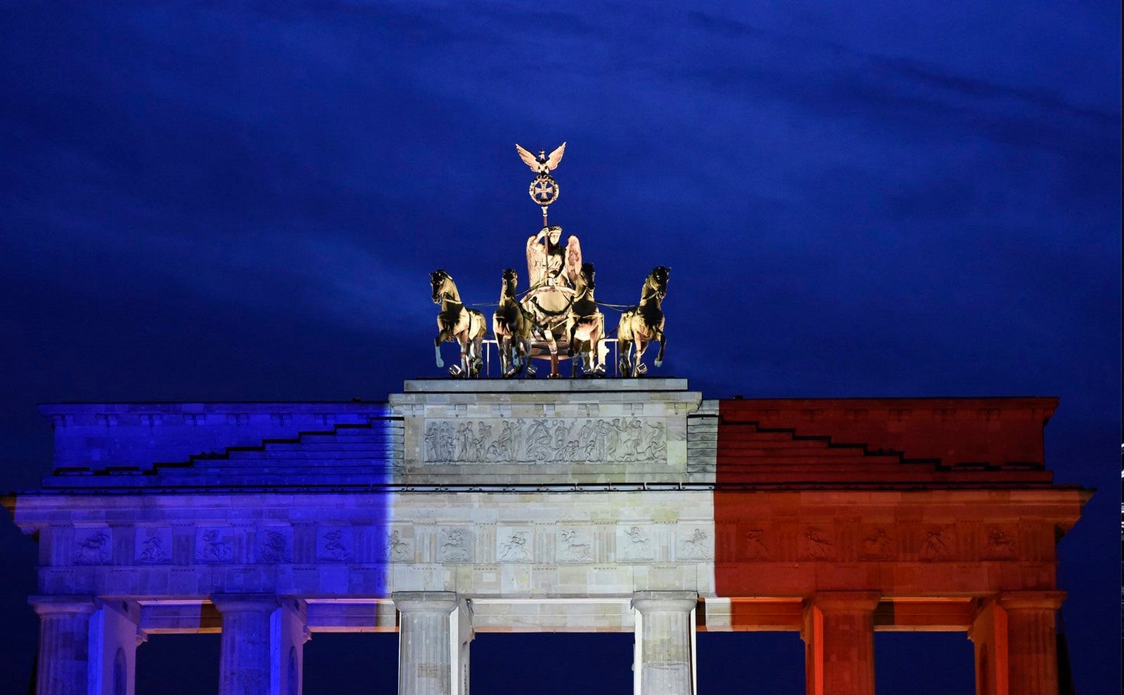 La puerta de Brandeburgo en Berlín, iluminado con los tri-colores de la bandera nacional francés en memoria de los fallecidos en los atentados de París.