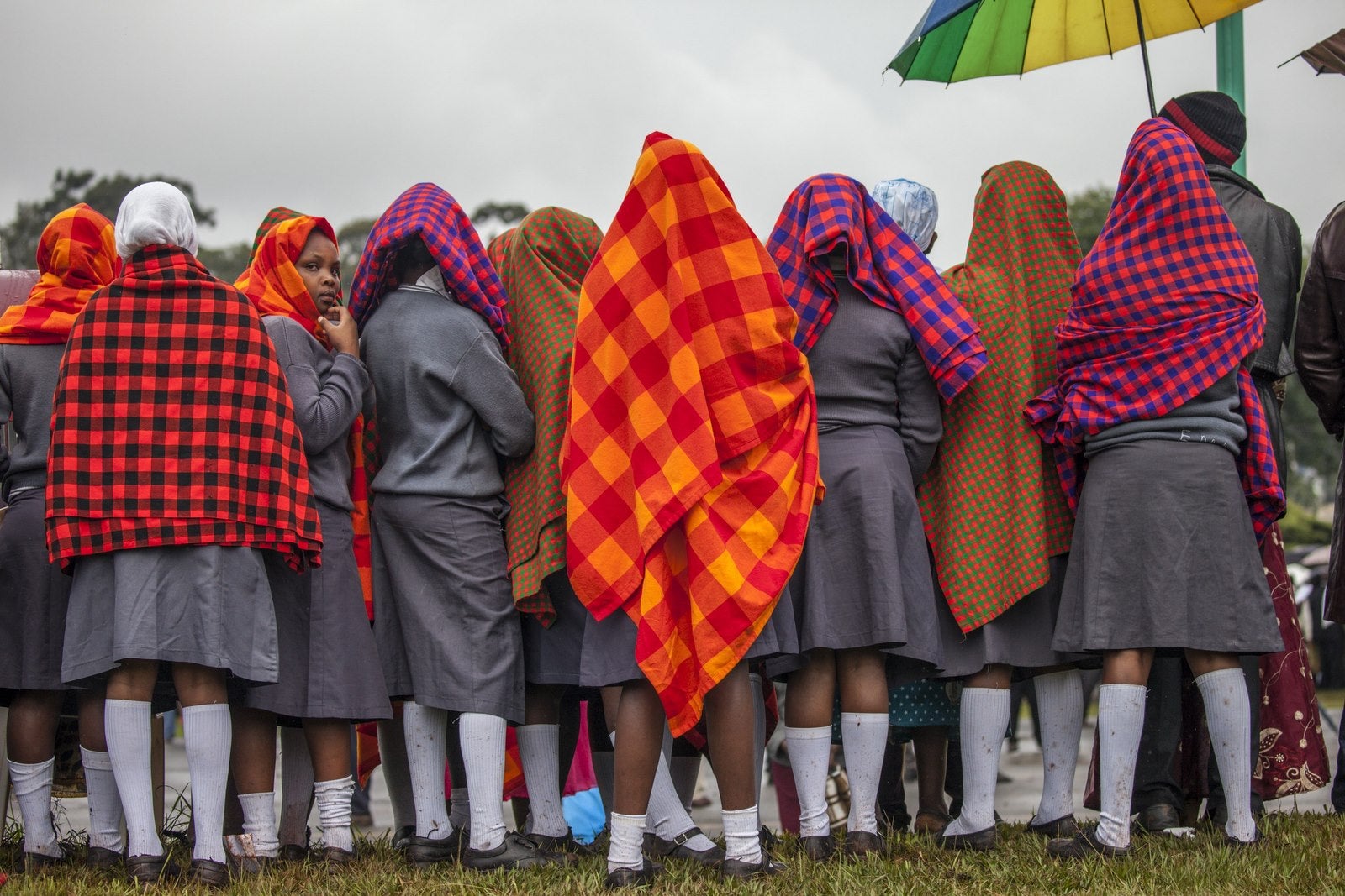 Las mujeres jóvenes se reúnen bajo la lluvia en la Universidad de Nairobi antes de una misa al aire libre pronunciado por el Papa.