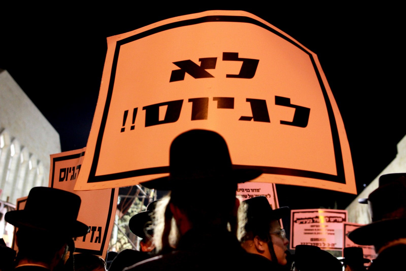 Un manifestante judío ultra-ortodoxo sostiene un cartel que lee en hebreo "Sin servicio" durante una manifestación en contra de los planes para poner fin a la exención de los jóvenes ultra ortodoxos que estudian en seminarios del servicio militar.