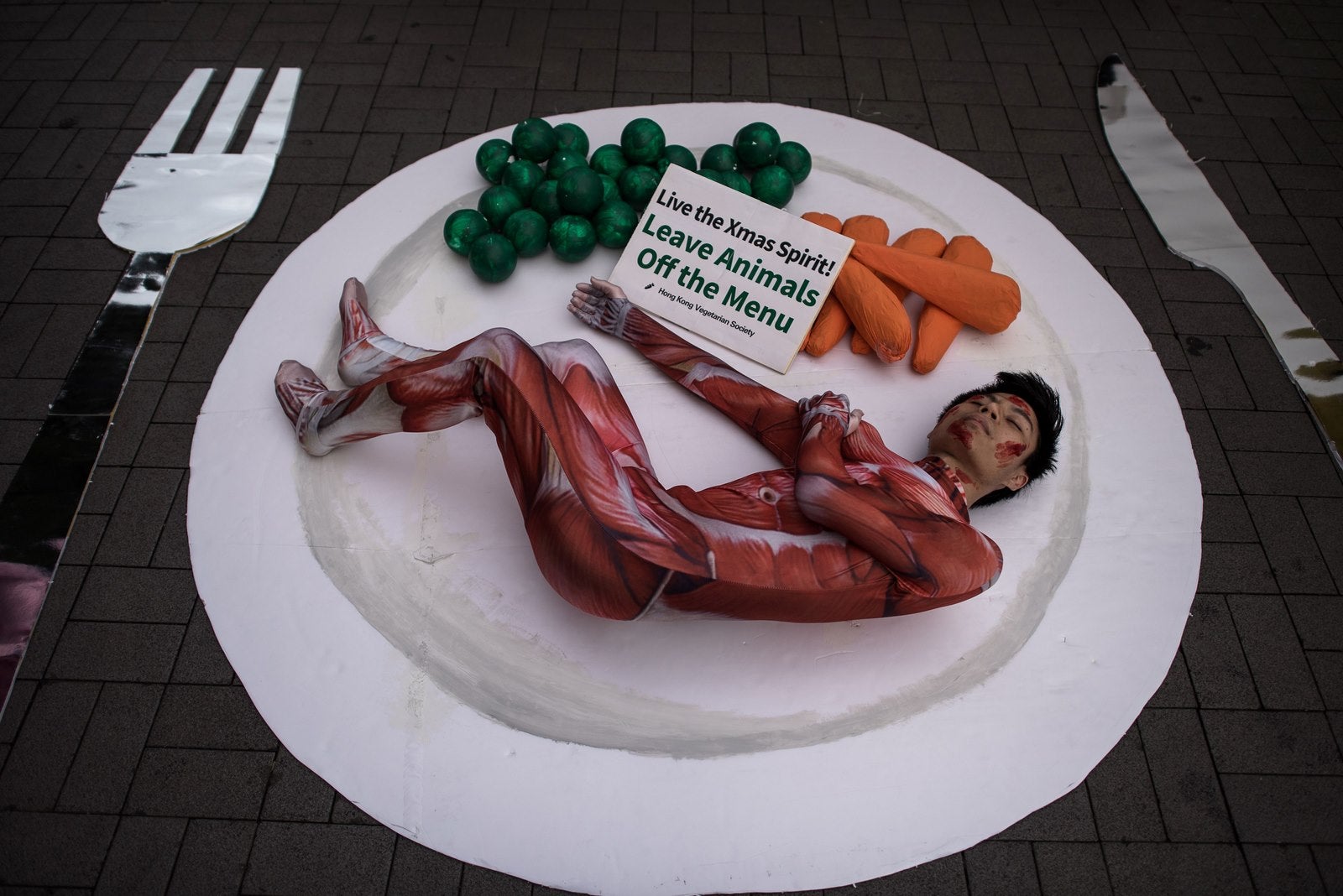 Un activista de la Sociedad Vegetariana de Hong Kong simulada como un plato de carne en un en Hong Kong.