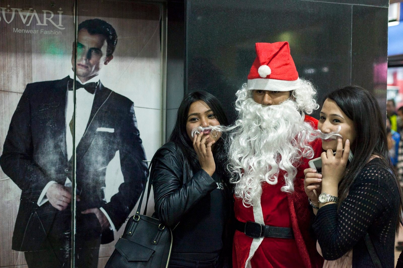 Dos Jóvenes posan con Papá Noel el día de Navidad en Katmandú (Nepal).