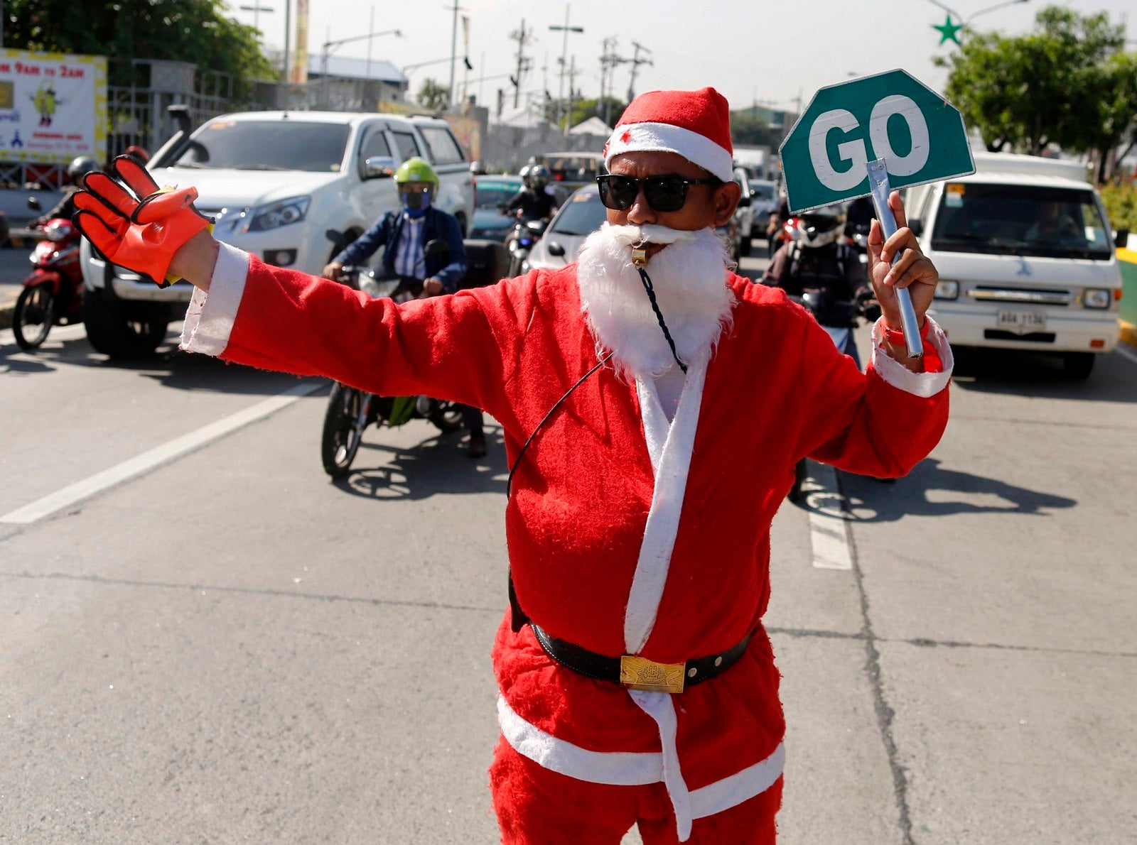 Un Guardia de Seguridad filipino, disfrazado de Papá Noel, Dirige el Tráfico Delante del centro comercial en la Localidad de Paranaque, sur de Manila (Filipinas).