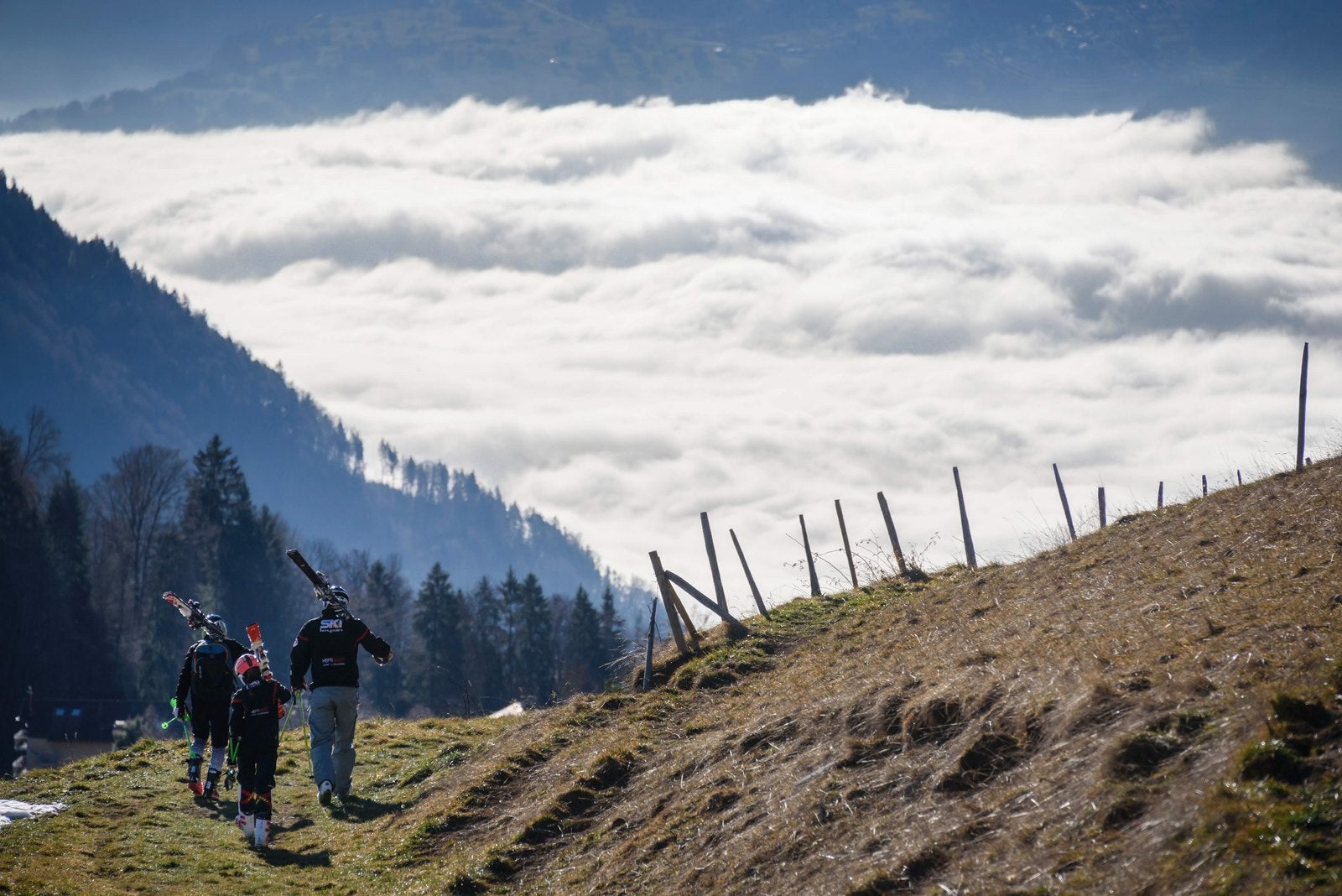 Turistas a pie sobre una colina sin nieve va a la estación de esquí de Leysin, Alpes suizos.