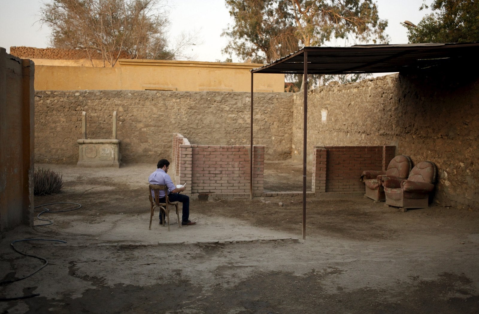 Un hombre lee el Corán frente a la tumba de su padre dentro de la necrópolis de El Cairo, Egipto.