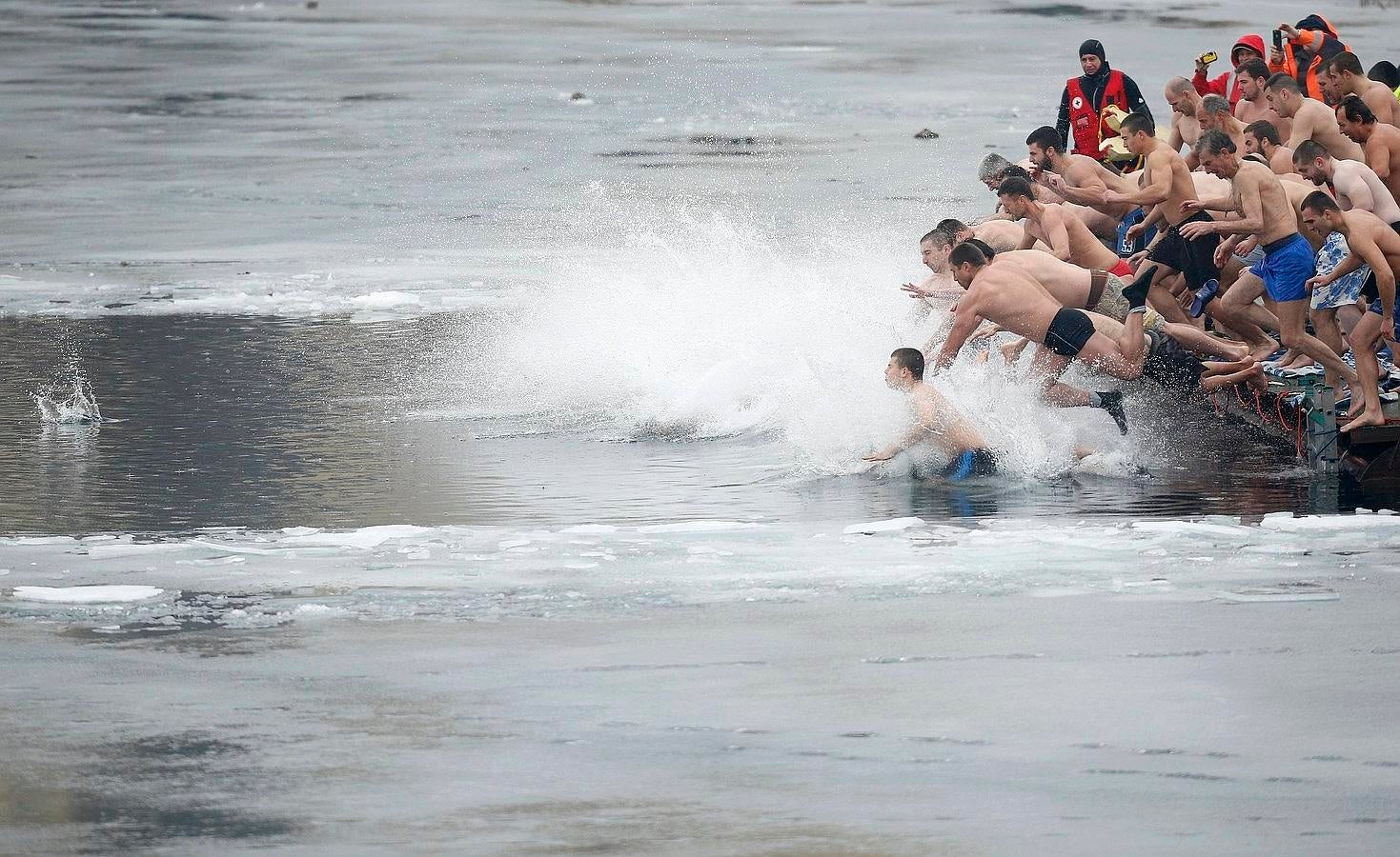 Participantes saltan en las aguas de un lago en un intento de apoderarse de una cruz de madera en el día de la Epifanía en Sofía, Bulgaria.