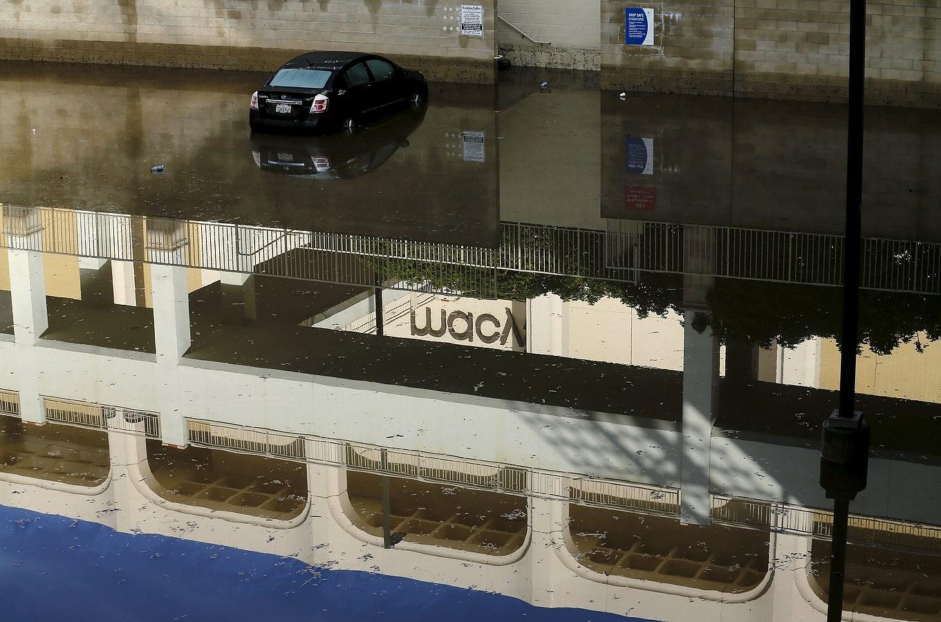 Un coche abandonado en las aguas de un centro comercial inundado, después de la tormenta que el trajo el Niño a San Diego, California.