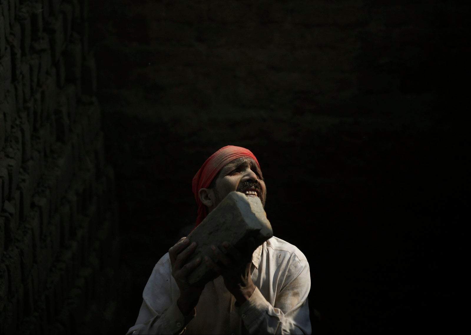 Un trabajador inmigrante de la india, pasa ladrillos en una fábrica de ladrillos en Lalitpur, Nepal.