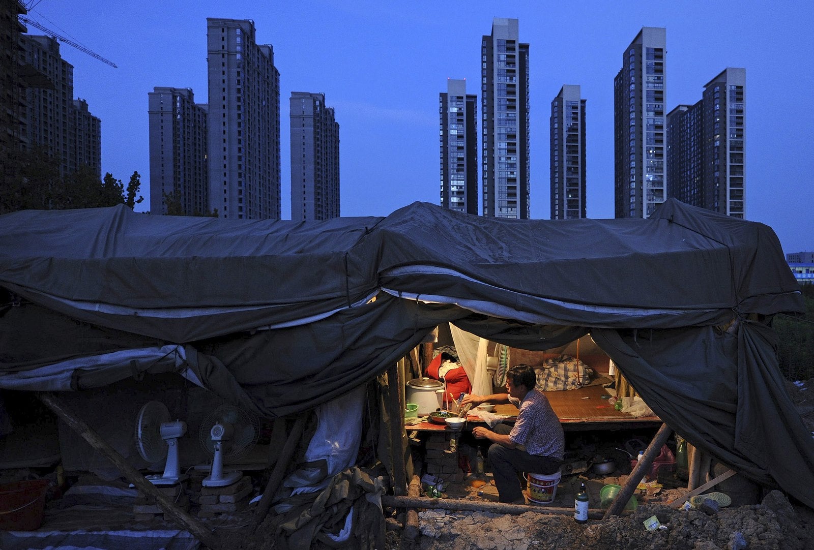 Un trabajador cena bajo su cobertizo en una construcción de un complejo residencial en Hefei, provincia de Anhui.