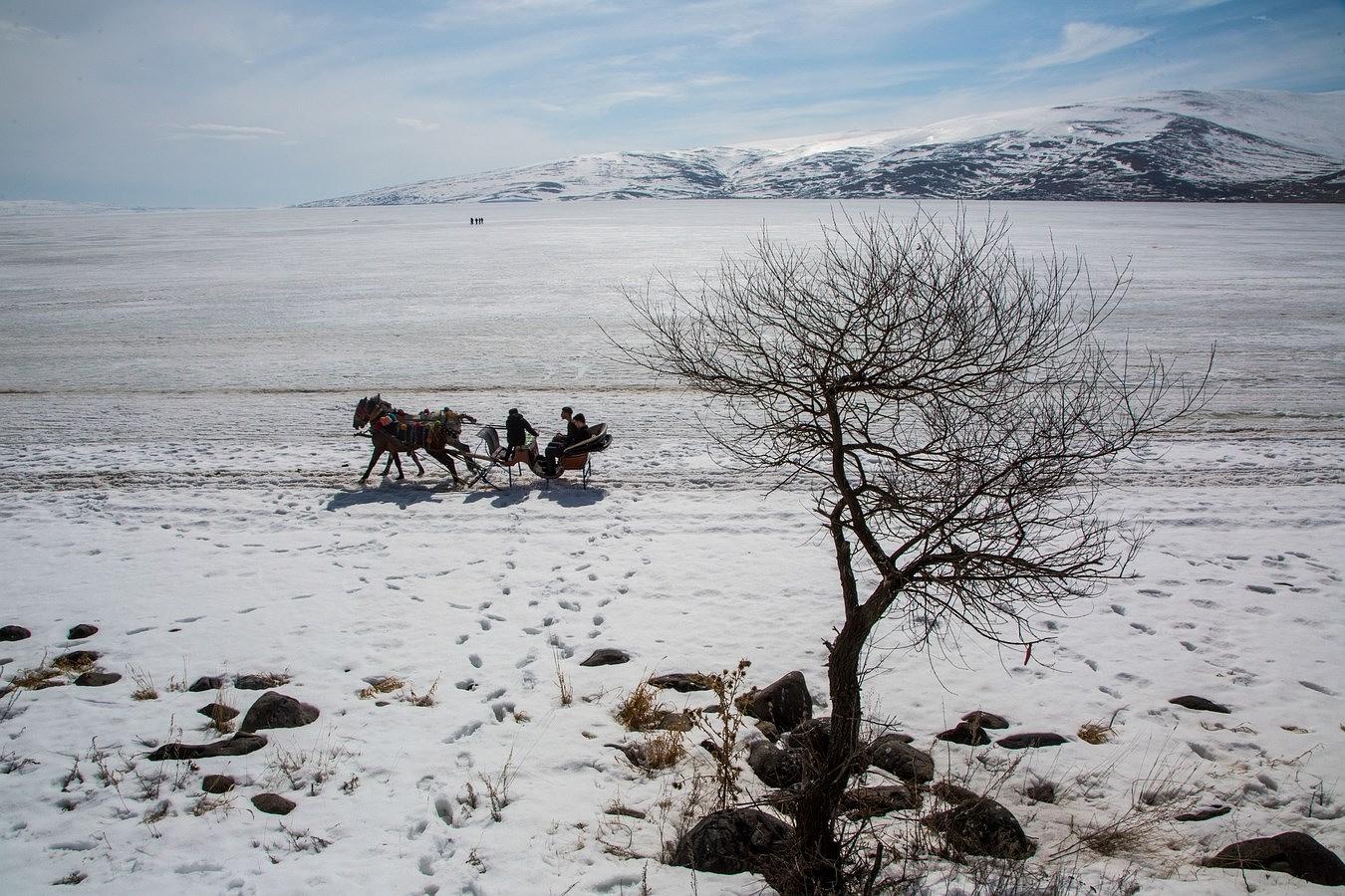 Un hombre monta sobre el carro en el lago congelado "Lago Cildir" en Ardahan Provincia de Turquía