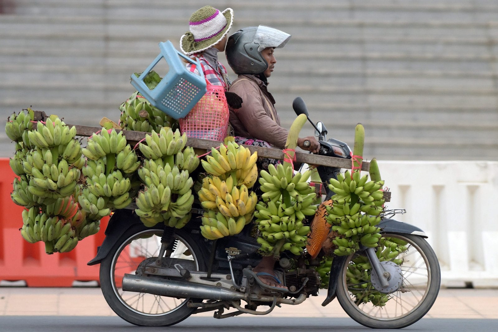 Un hombre de Camboya monta su moto cargada de plátanos que viajan a lo largo de una calle en Phnom Penh.