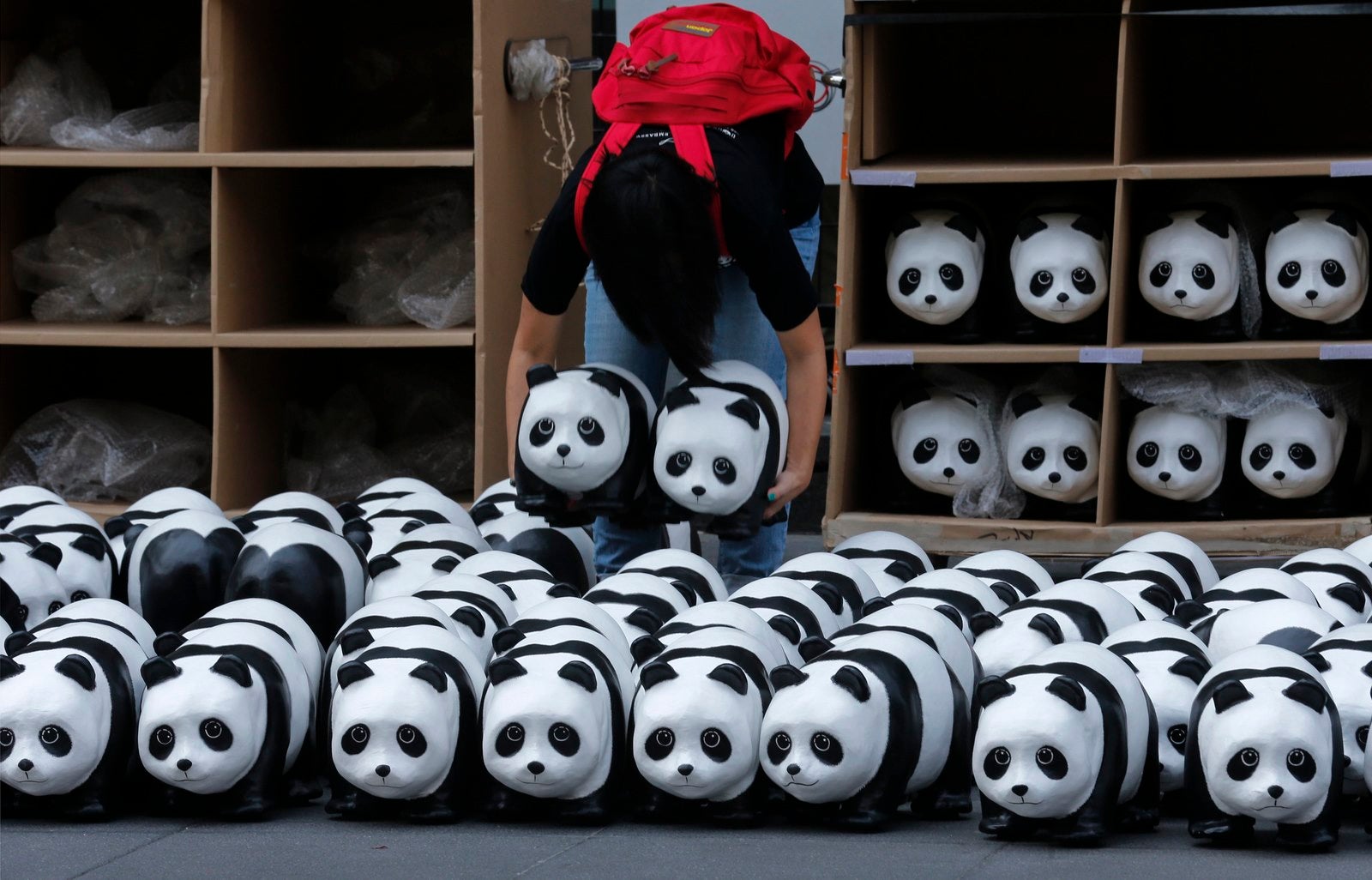 Un voluntario mueve esculturas panda de una exposición del artista francés Paulo Grangeon fuera de un centro comercial en Bangkok, Tailandia.