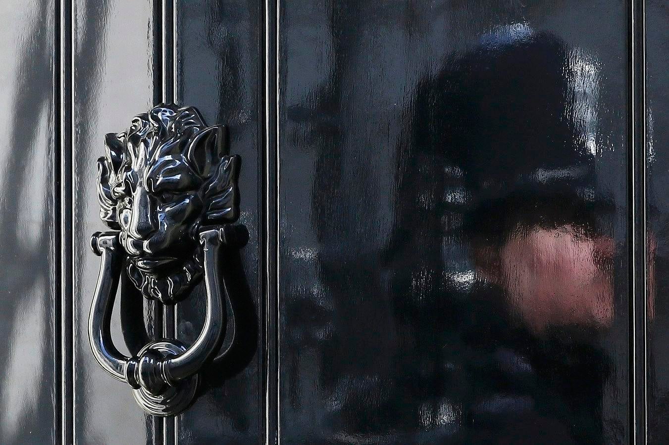 Un oficial de policía se refleja en la puerta del 10 de Downing Street en Londres, Reino Unido.