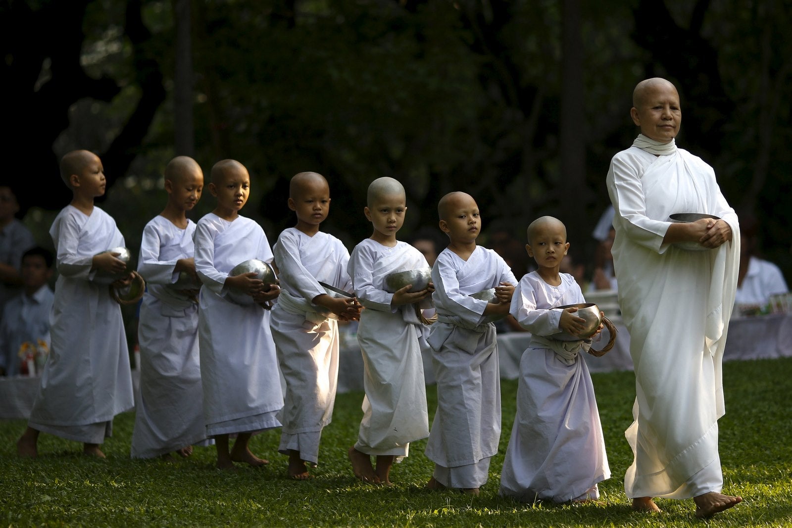 Una monja budista camina en línea con las novicias para recibir la comida de la gente durante el festival de Songkran en el centro de meditación Sathira-Dhammasathan budista en Bangkok, Tailandia.