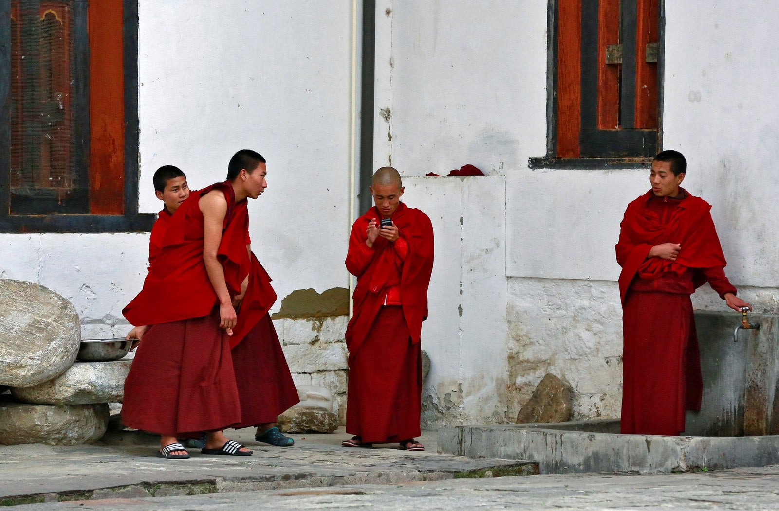 Un monje mira a su teléfono móvil en Tashichho Dzong, el asiento de la primera autoridad civil de Bhután en Thimphu, Bhután.