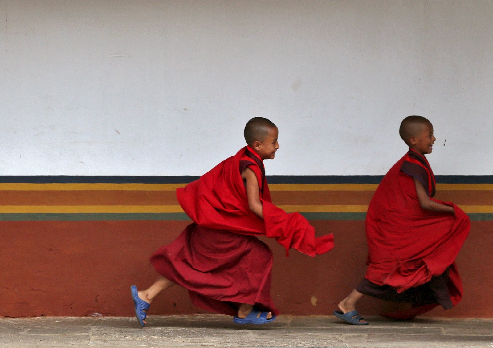 Monjes jóvenes juegan dentro de la Punakha Dzong, Bután