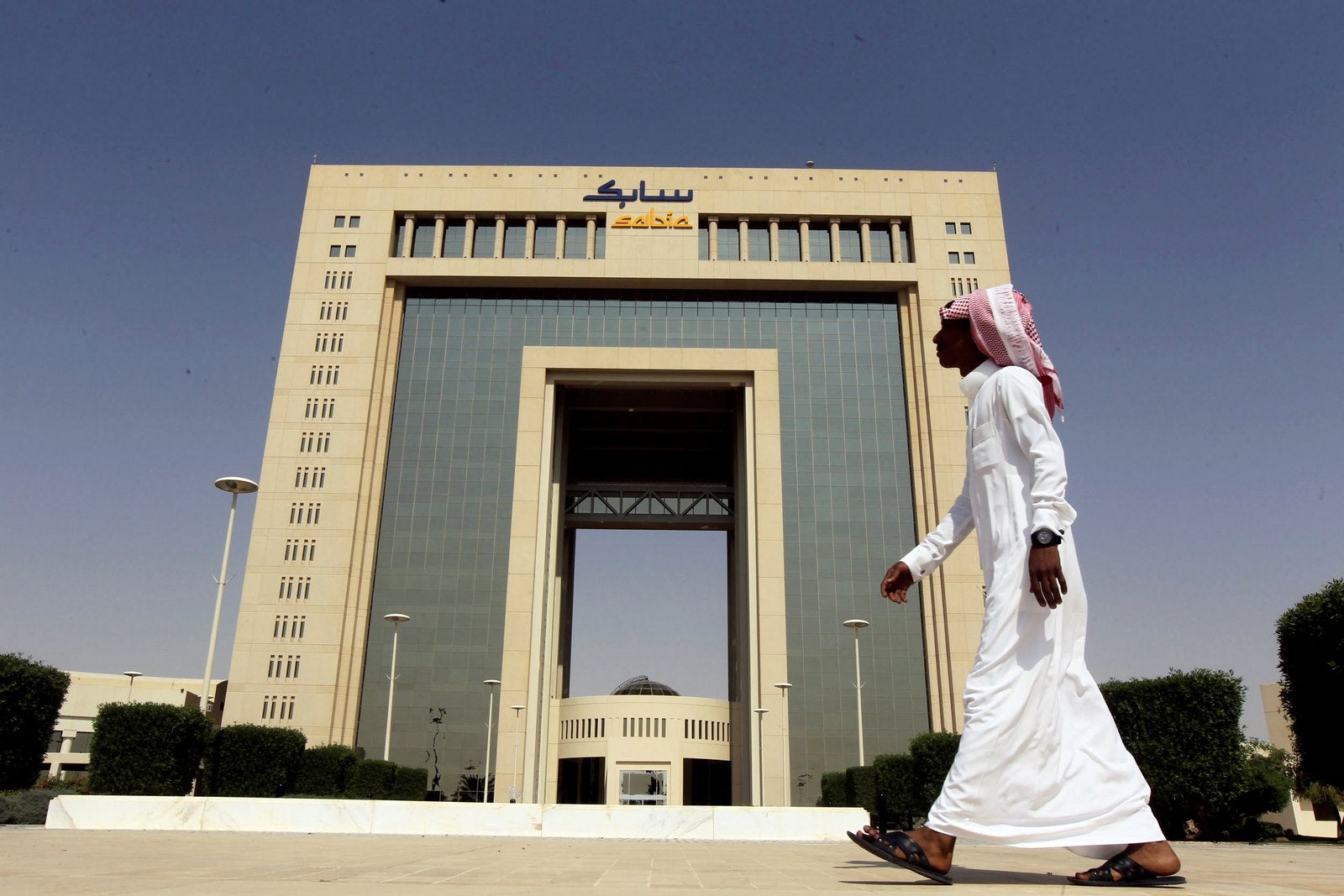 Un hombre pasa junto a la sede de Saudi Basic Industries Corp (SABIC) en Riad, Arabia.